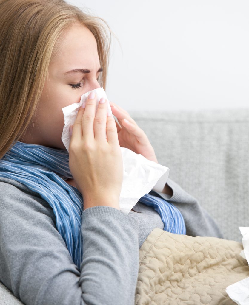 Woman blowing her nose into a tissue