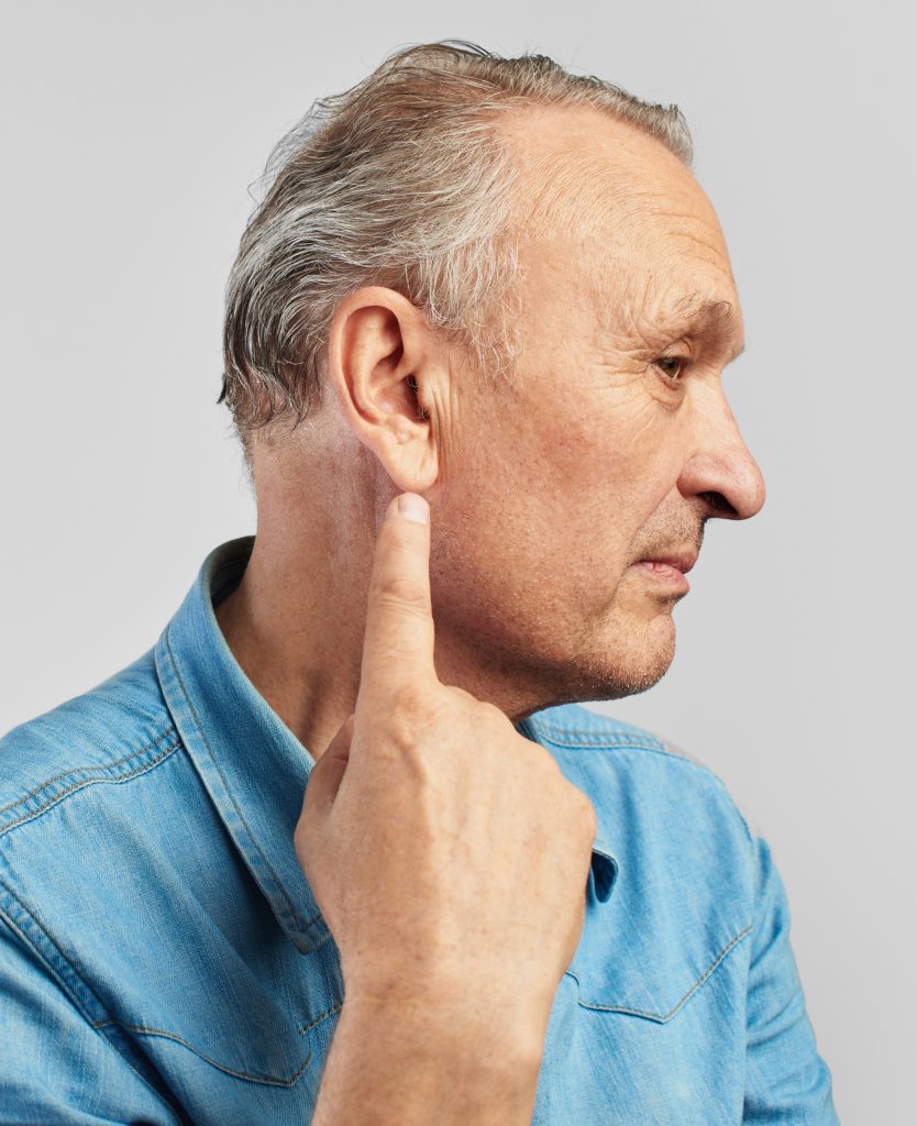 Man pointing at his ear