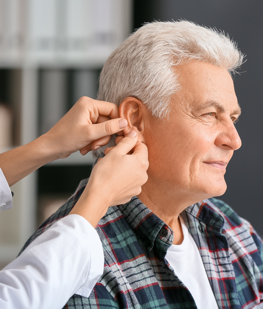 Doctor inspecting an older man's ear