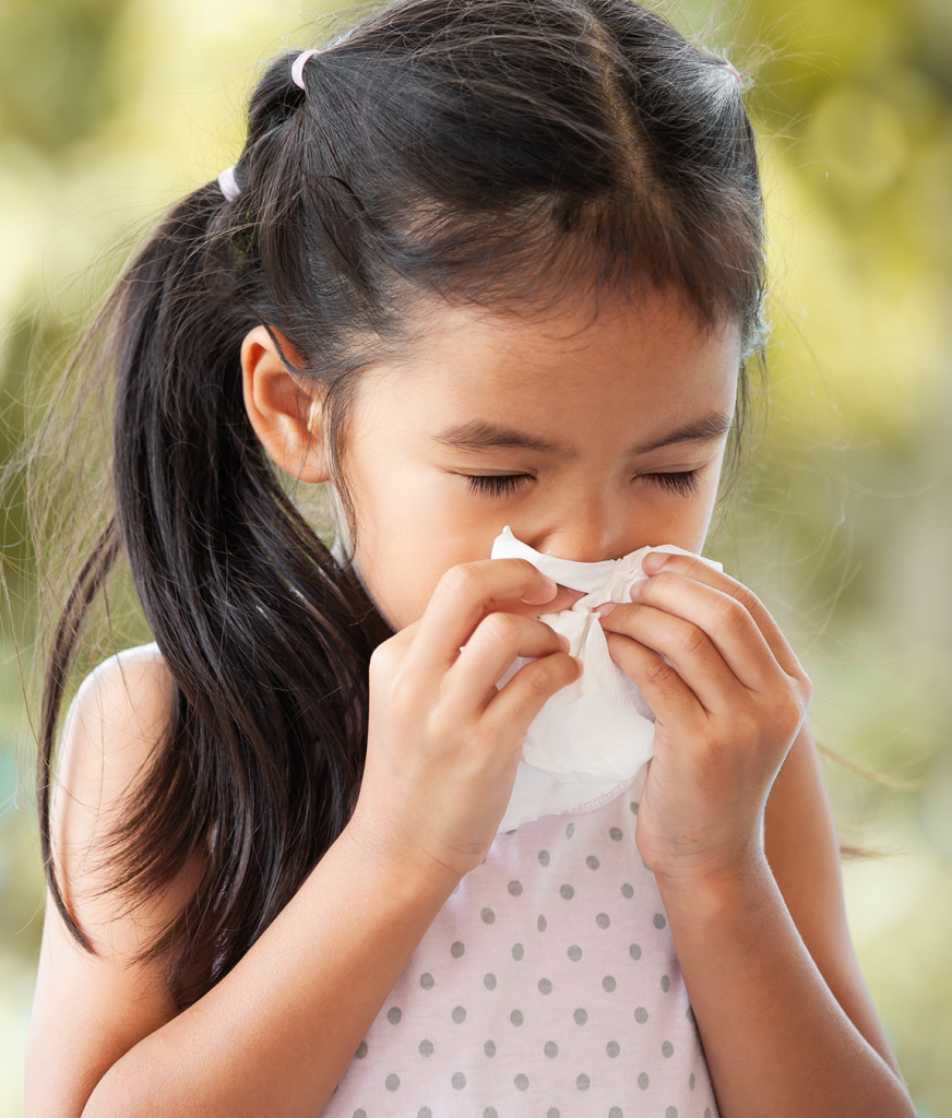 Little girl blowing her nose