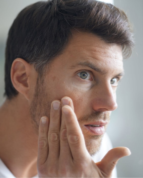 Man checking his face for age spots