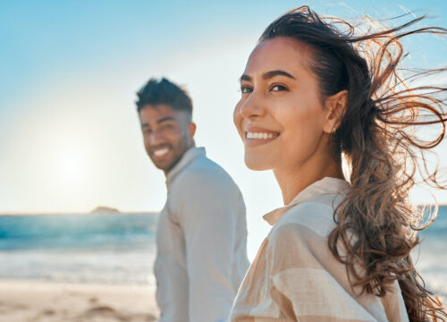 Photo of a happy couple walking on the beach